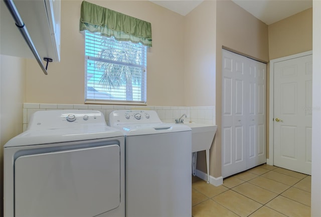 clothes washing area featuring laundry area, independent washer and dryer, and light tile patterned floors