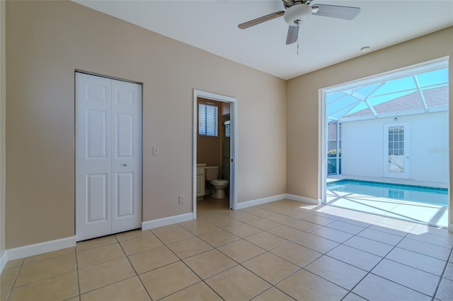 empty room featuring ceiling fan, baseboards, and light tile patterned floors