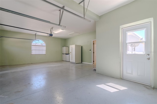 garage with white fridge with ice dispenser, a garage door opener, and freestanding refrigerator