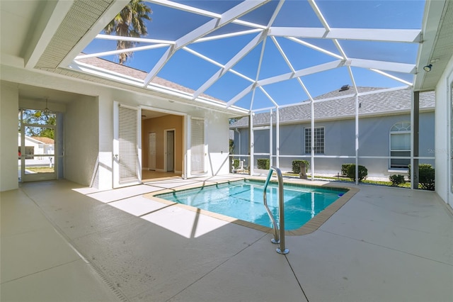 outdoor pool with a patio and glass enclosure