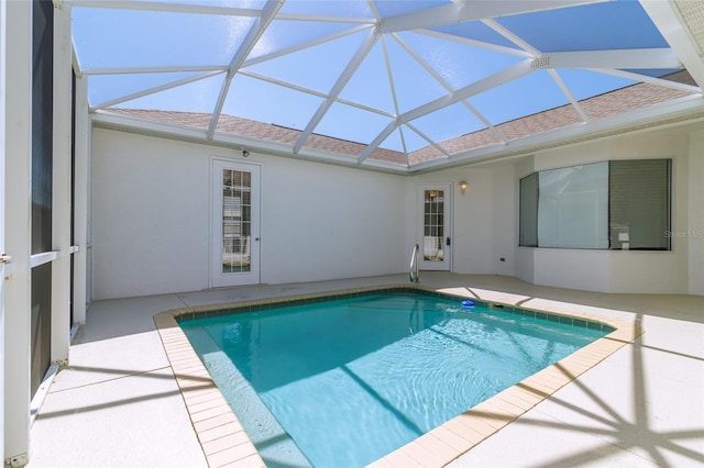 pool featuring glass enclosure and a patio area