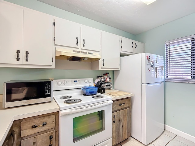 kitchen with white appliances, white cabinets, light countertops, under cabinet range hood, and light tile patterned flooring