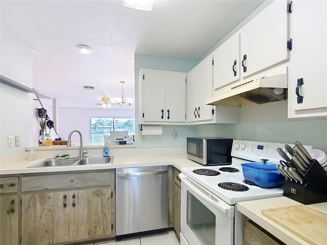 kitchen featuring appliances with stainless steel finishes, light countertops, a sink, and under cabinet range hood