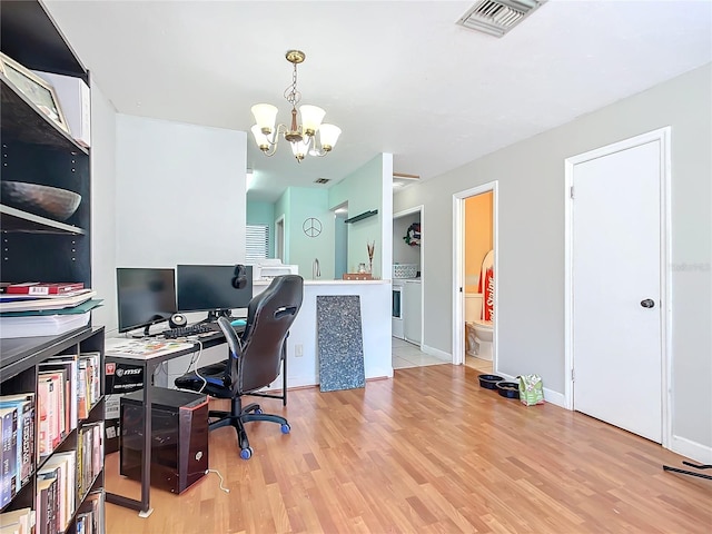 home office featuring baseboards, visible vents, an inviting chandelier, and wood finished floors