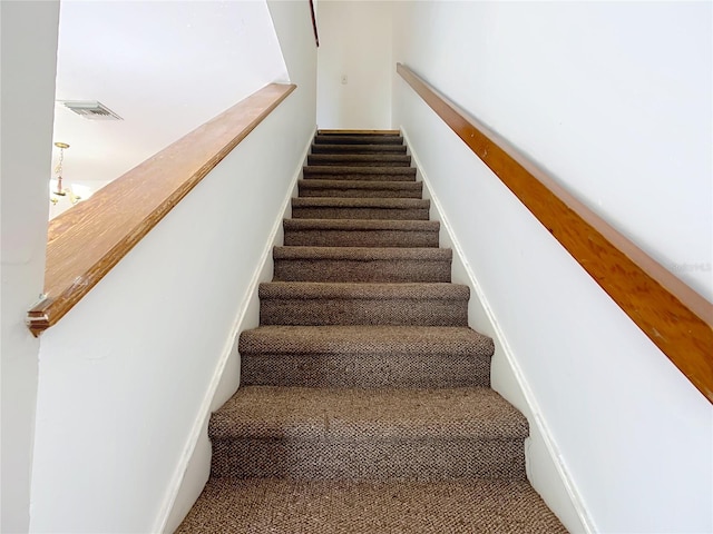 staircase with carpet and visible vents