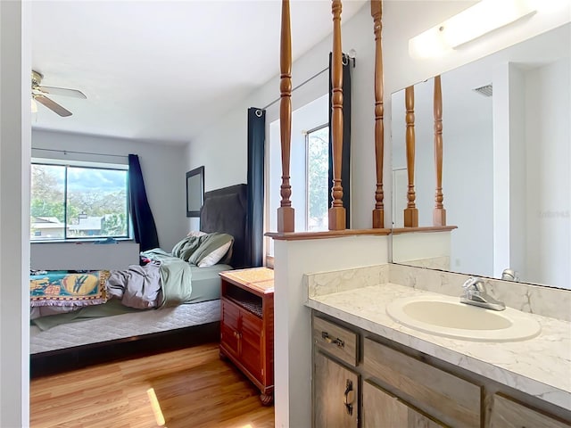 ensuite bathroom featuring ceiling fan, wood finished floors, ensuite bath, and vanity