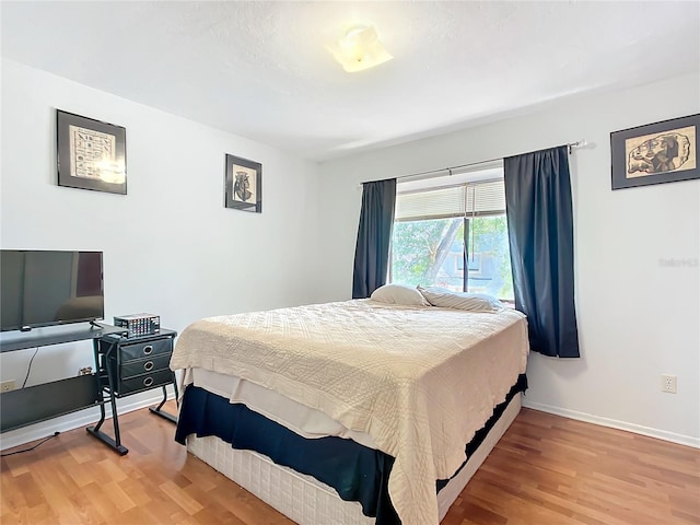 bedroom with light wood-style flooring and baseboards