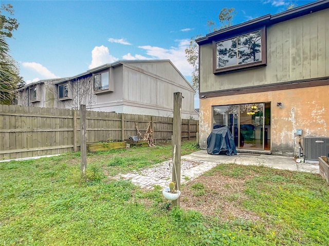 view of yard featuring fence and central AC