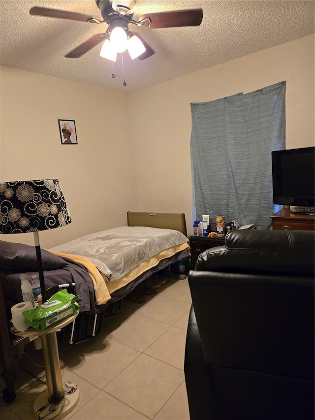 bedroom featuring light tile patterned floors, a textured ceiling, and ceiling fan