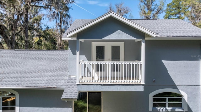 view of property exterior featuring a shingled roof, a balcony, and stucco siding