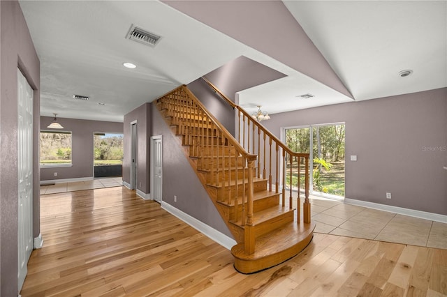 stairway featuring hardwood / wood-style flooring, baseboards, visible vents, and recessed lighting