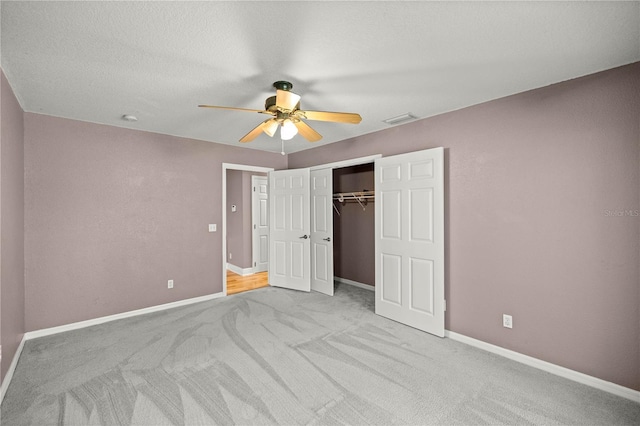 unfurnished bedroom with baseboards, visible vents, a closet, and light colored carpet