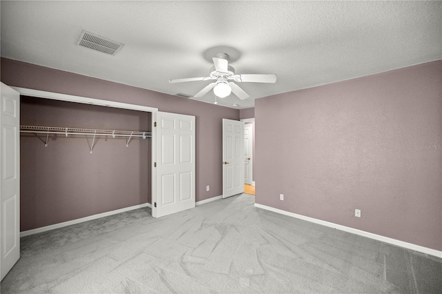 unfurnished bedroom with baseboards, visible vents, a ceiling fan, carpet, and a closet