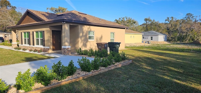 view of property exterior with stucco siding, a shingled roof, and a yard