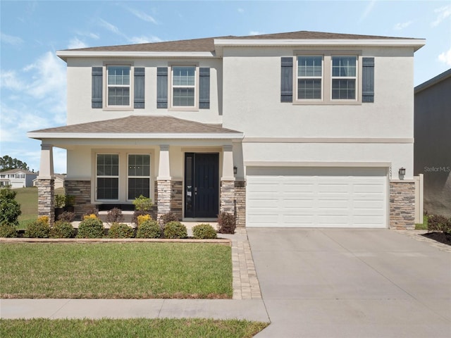 view of front facade with an attached garage, stone siding, concrete driveway, and stucco siding