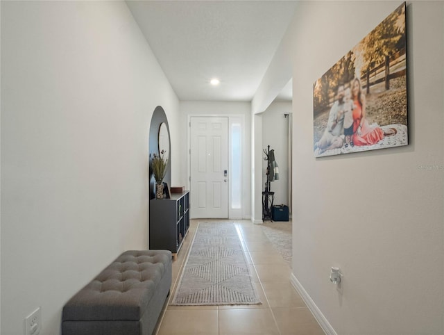 foyer entrance with light tile patterned floors and baseboards