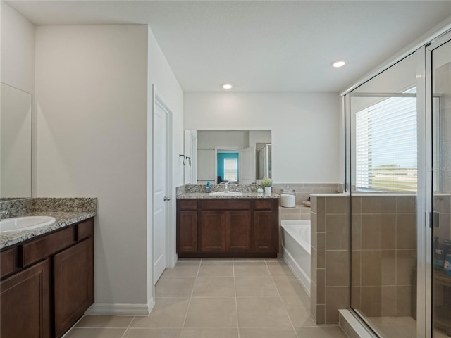 full bathroom featuring two vanities, tile patterned floors, a sink, a shower stall, and a bath