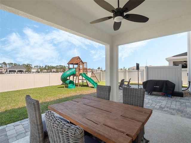 view of patio / terrace with outdoor dining space, a fenced backyard, a playground, and ceiling fan