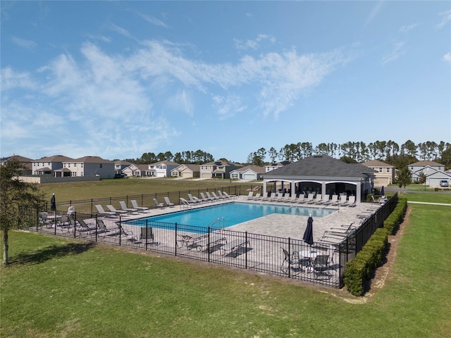 community pool featuring a patio area, a lawn, a gazebo, and fence