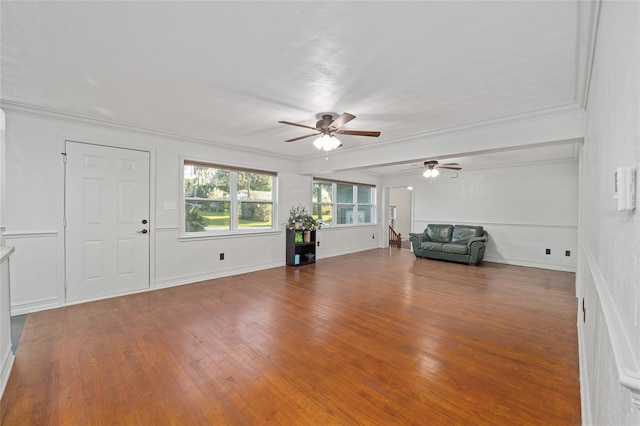 unfurnished living room featuring ornamental molding, wood finished floors, and baseboards