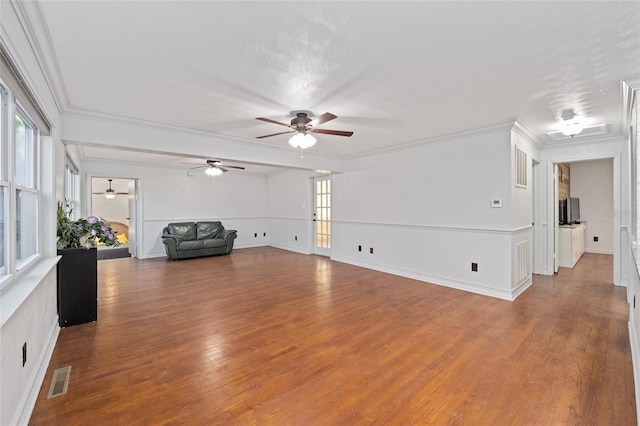 unfurnished living room featuring visible vents, crown molding, and wood finished floors