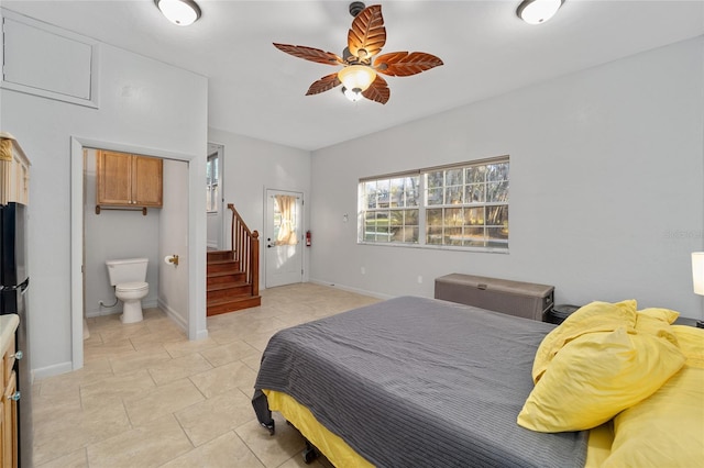 bedroom with a ceiling fan, light tile patterned floors, baseboards, and ensuite bathroom