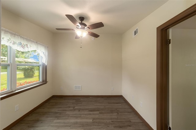 unfurnished room with baseboards, visible vents, and wood finished floors