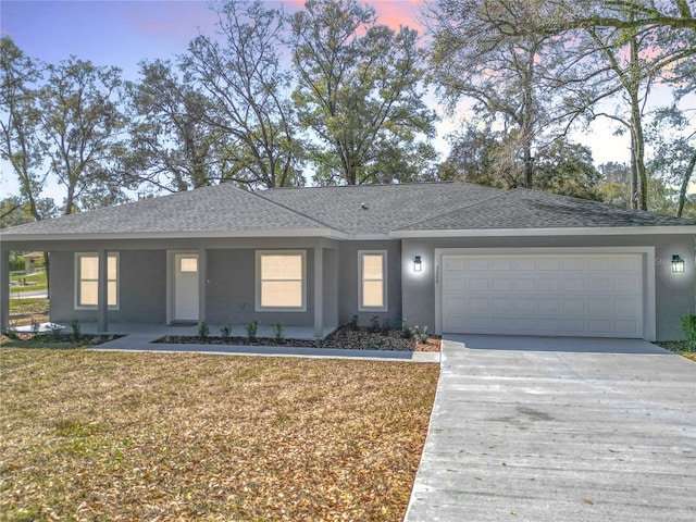 ranch-style home with concrete driveway, roof with shingles, an attached garage, and stucco siding