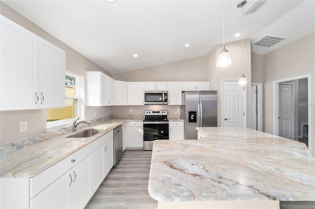 kitchen with stainless steel appliances, lofted ceiling, visible vents, a sink, and a kitchen island