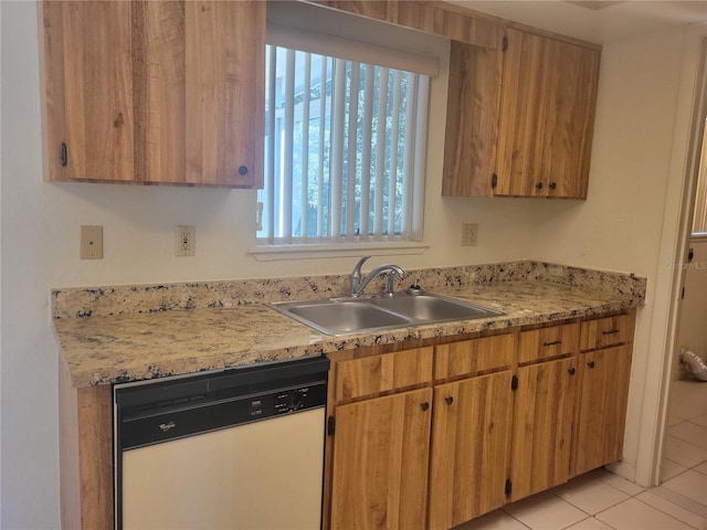 kitchen featuring brown cabinets, white dishwasher, light countertops, a sink, and light tile patterned flooring