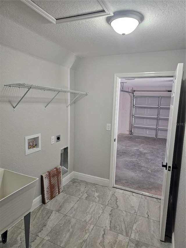 laundry area with a garage, laundry area, a textured ceiling, hookup for an electric dryer, and washer hookup