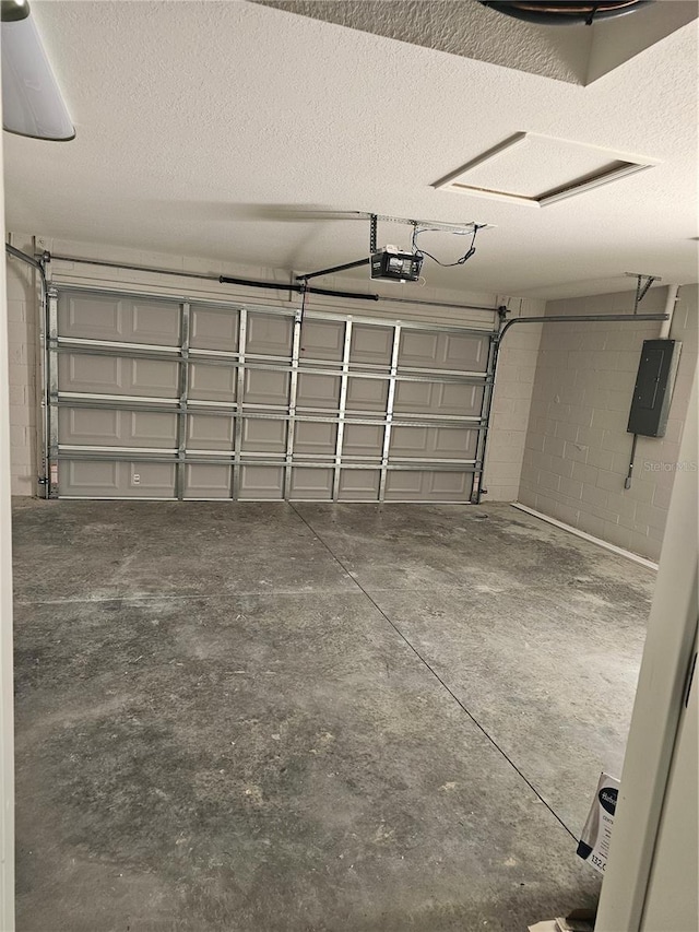 garage featuring concrete block wall, electric panel, and a garage door opener