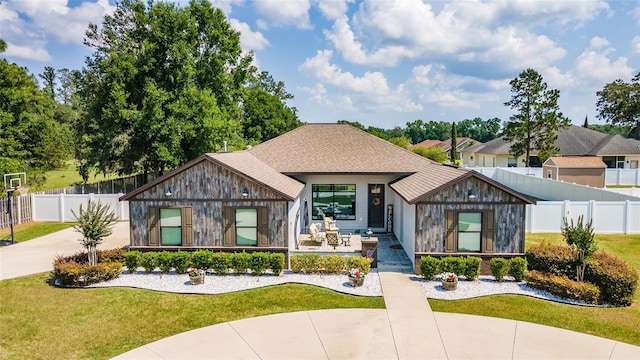 view of front of home with a front yard and fence