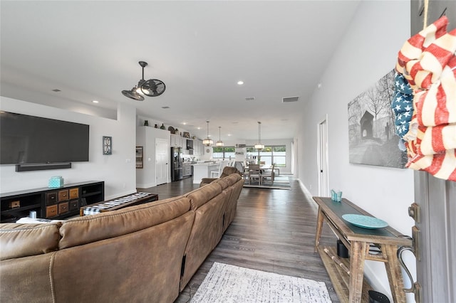 living room featuring baseboards, dark wood-style flooring, visible vents, and recessed lighting