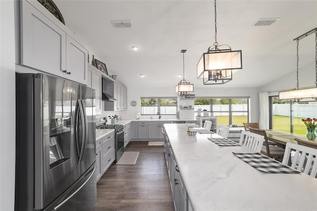 kitchen featuring stainless steel appliances, visible vents, vaulted ceiling, dark wood finished floors, and pendant lighting