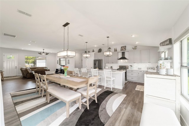 dining room with lofted ceiling, light wood finished floors, visible vents, and recessed lighting