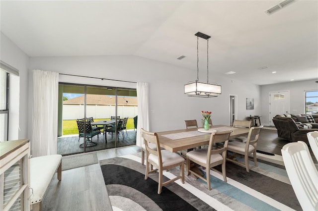 dining room with vaulted ceiling, a wealth of natural light, wood finished floors, and visible vents