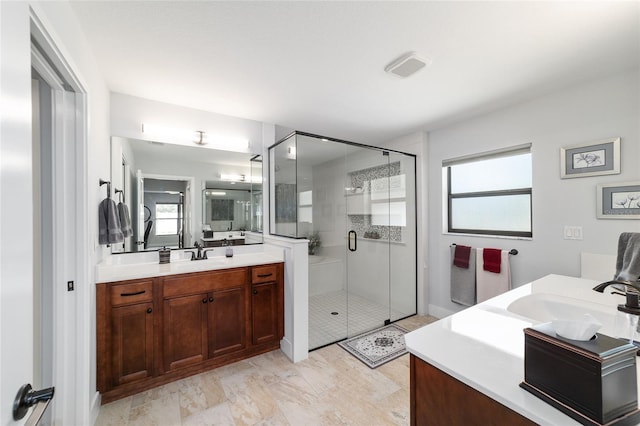 full bath featuring a stall shower, two vanities, a sink, and visible vents