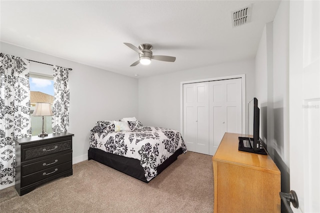 carpeted bedroom with a closet, visible vents, and a ceiling fan