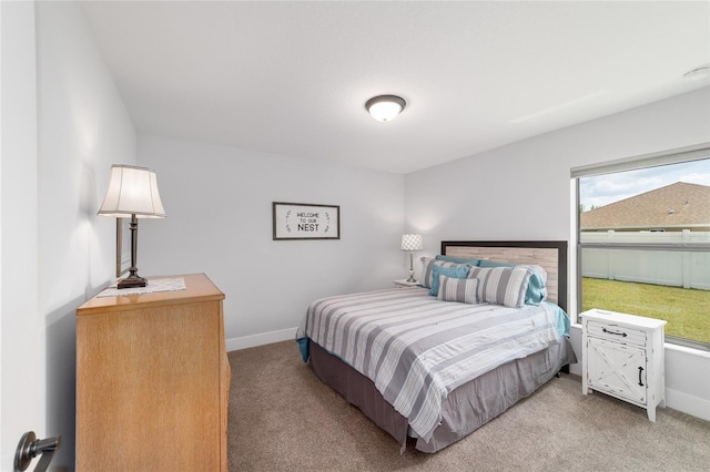 bedroom featuring light carpet and baseboards