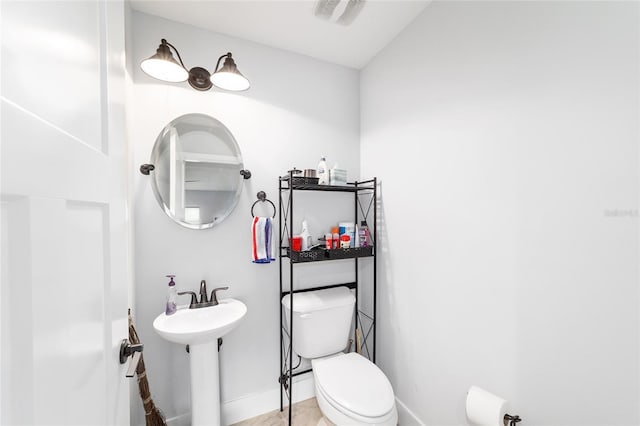 bathroom featuring baseboards, visible vents, and toilet