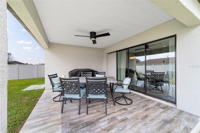 view of patio / terrace with ceiling fan, outdoor dining space, and fence