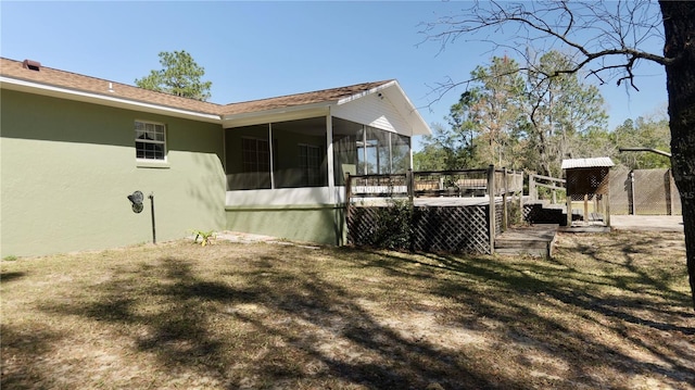 view of yard featuring a sunroom and a wooden deck