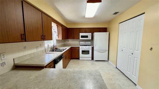 kitchen featuring visible vents, backsplash, a sink, a textured ceiling, and white appliances