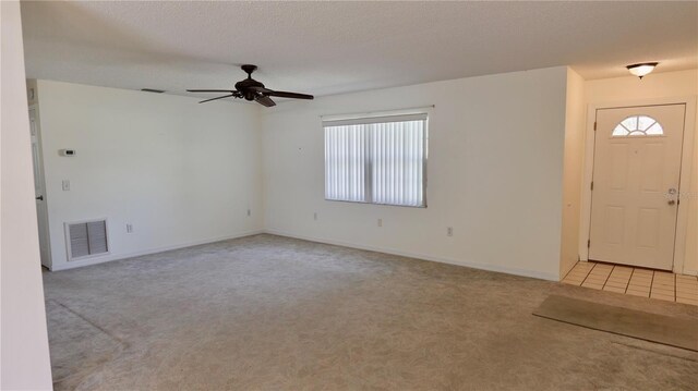 entryway featuring visible vents, a wealth of natural light, and light colored carpet