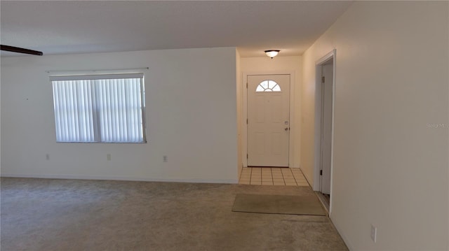 foyer featuring light carpet, light tile patterned floors, and plenty of natural light