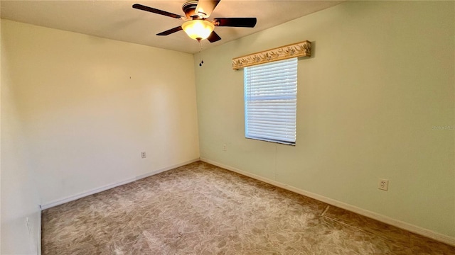 carpeted empty room with a ceiling fan and baseboards