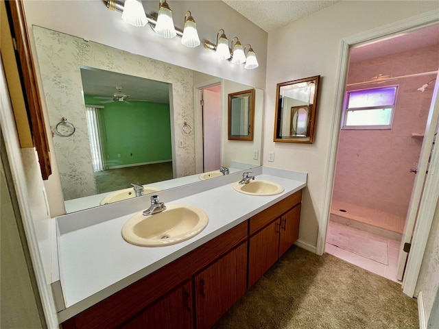 bathroom featuring double vanity, a sink, and wallpapered walls