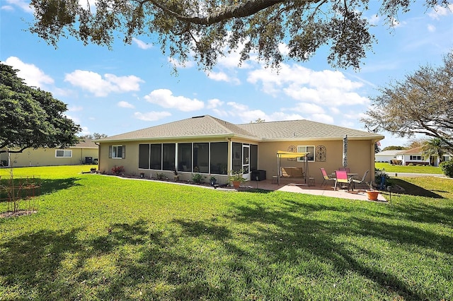 back of property featuring a sunroom, a patio area, a lawn, and stucco siding