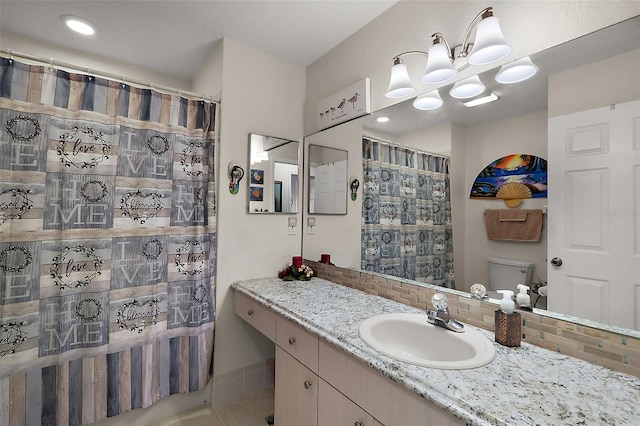 bathroom featuring tasteful backsplash, vanity, toilet, and curtained shower